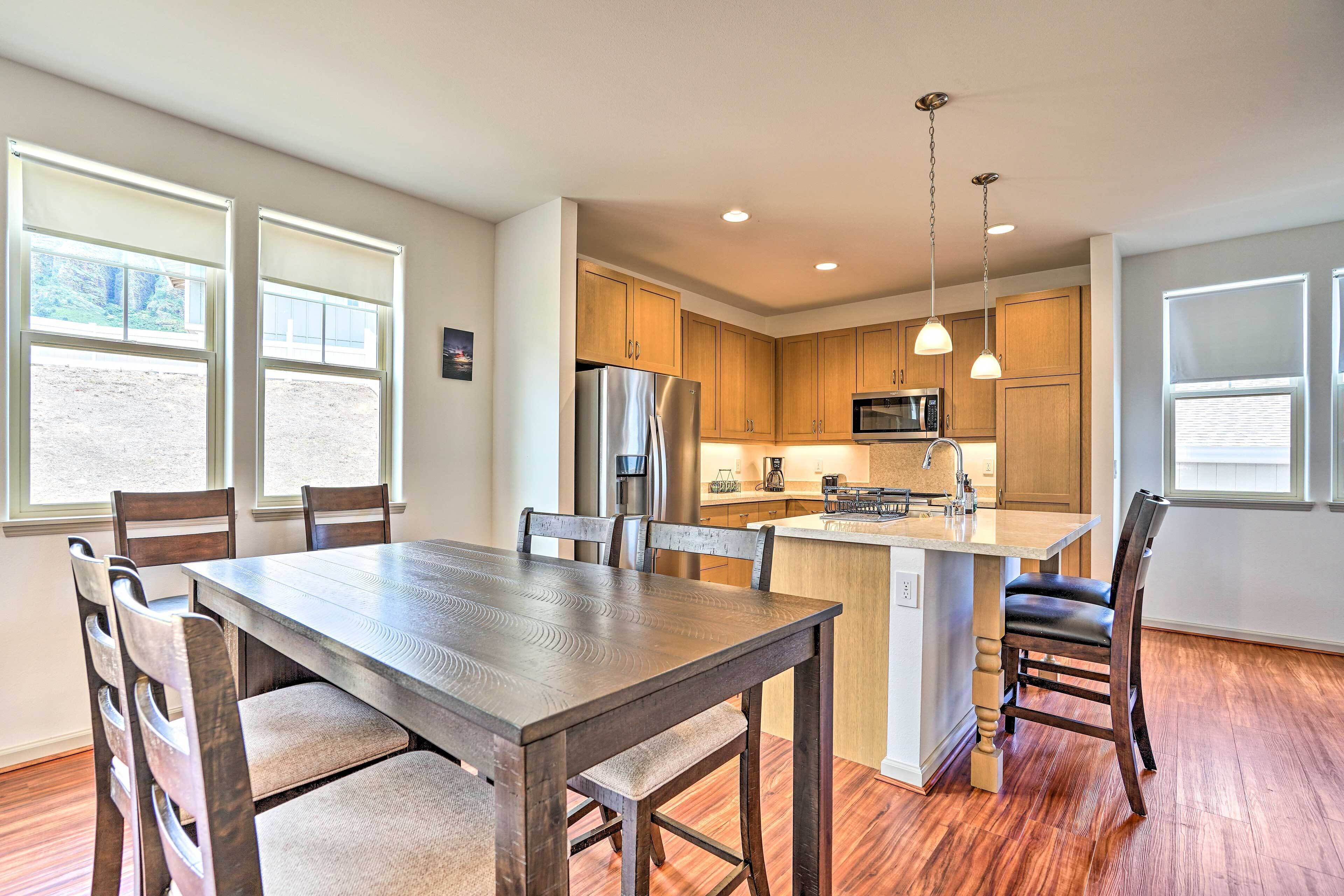 A modern kitchen with wooden cabinets, a stainless steel refrigerator, and a central island with seating.