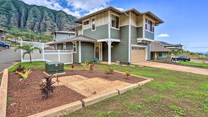 A two-story house with a front yard and a driveway. - Modern Waianae Home w/ Mountain & Valley View (Waianae)