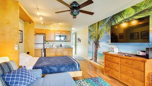 A bedroom with a bed, a dresser, a television, and a kitchen in the background. - Tropical Kailua-kona Escape < 7 Mi to Keauhou Bay! (Kailua-Kona)