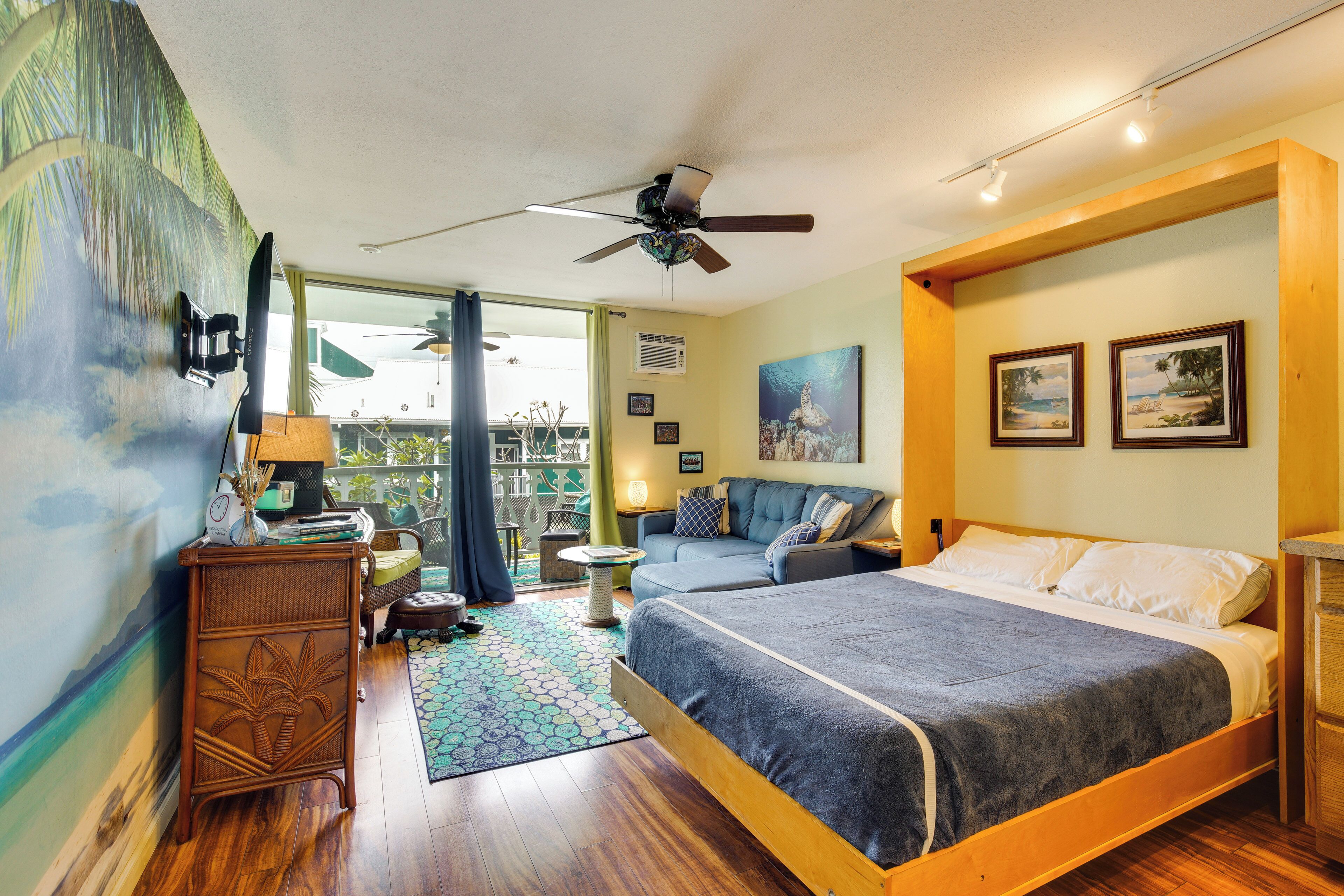 A bedroom with a bed, a ceiling fan, a window, and a view of the outdoors.