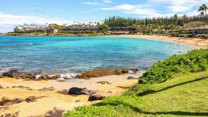 A beachfront hotel with multiple buildings, a sandy beach, and clear turquoise waters.