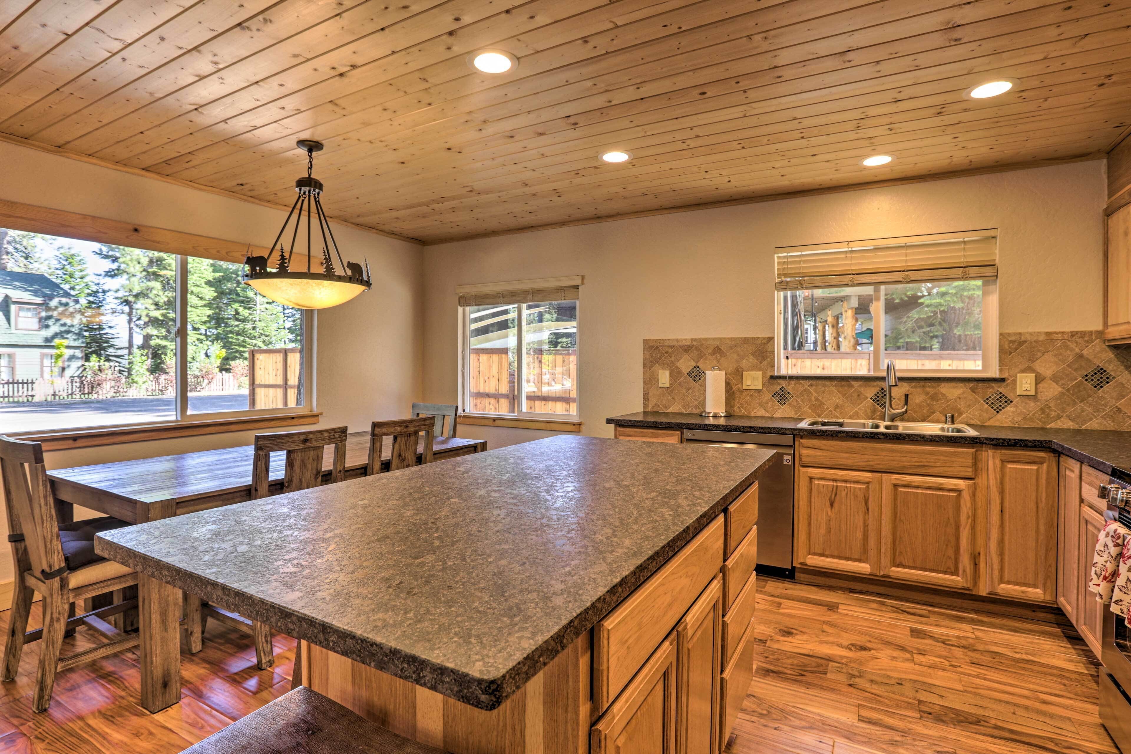 A kitchen with wooden cabinets, a granite countertop, and a large island.