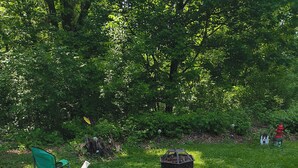 An outdoor dining area with green chairs and a table covered with a leaf-patterned tablecloth. - Charming 2-bedroom house with AC, WiFi in delightful Brainerd (Brainerd)
