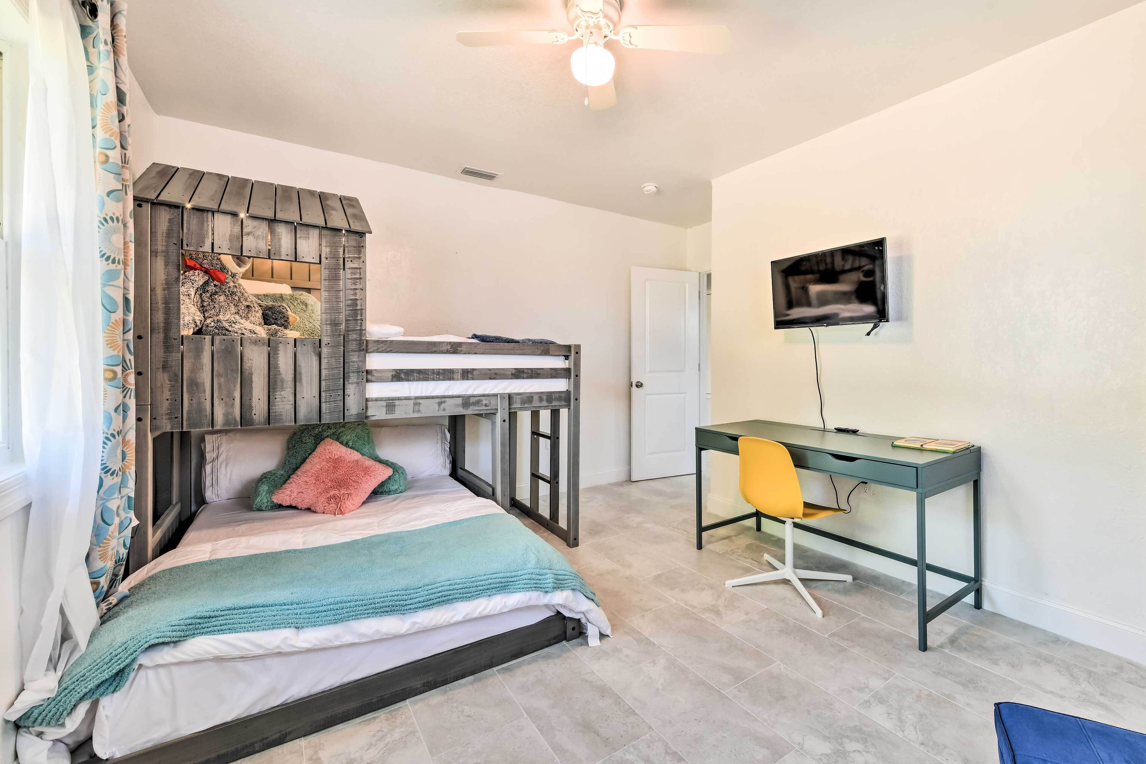 A bedroom with a bunk bed, a desk, and a chair.