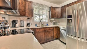 A modern kitchen with dark wooden cabinets, stainless steel appliances, and a large refrigerator. - Bright, Pet-friendly Retreat in Avon Park! (Avon Park)