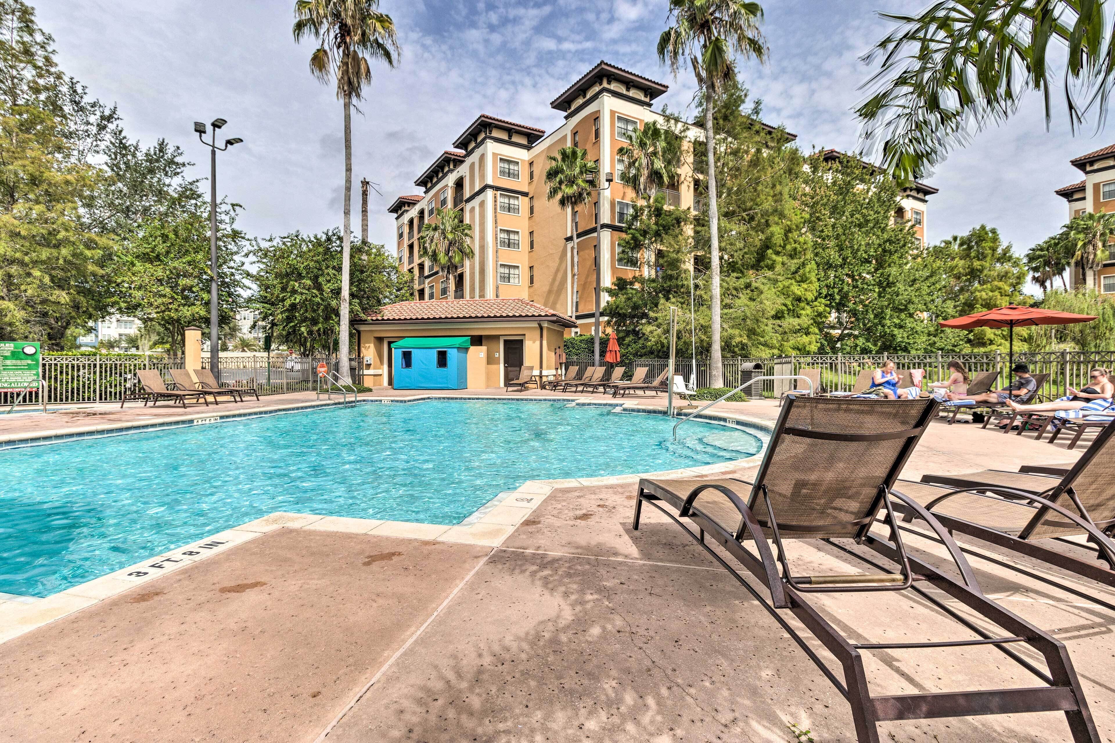 A swimming pool with lounge chairs and a small building with a blue door.
