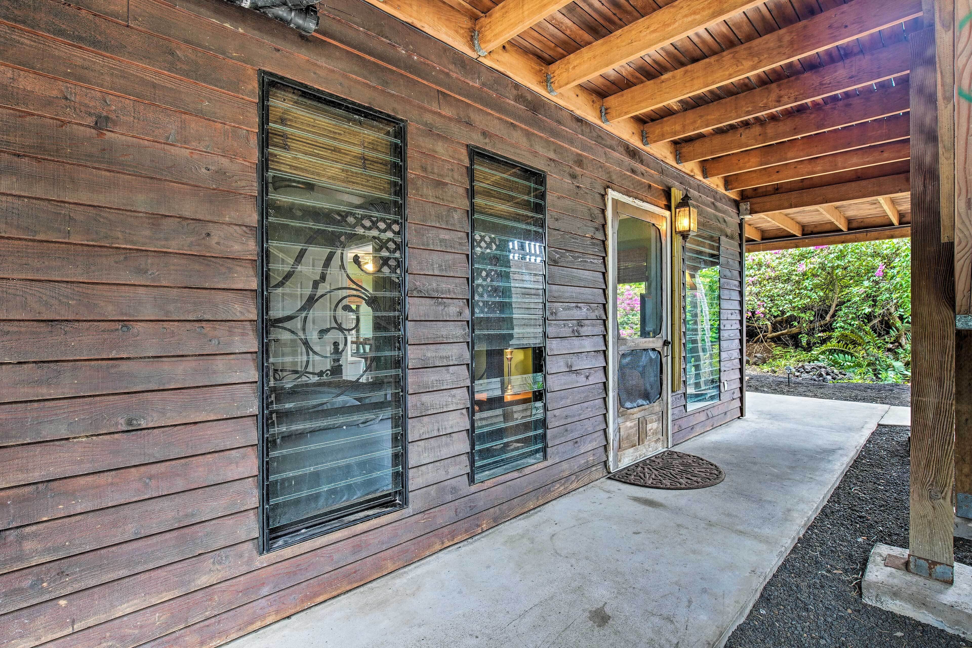 A wooden exterior with large windows and a covered porch area.