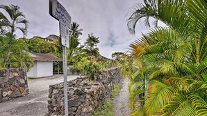 A stone wall, a sign, and lush greenery.