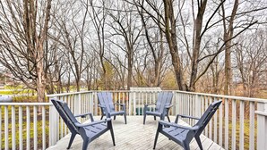 A wooden deck with two Adirondack chairs facing a white railing. - Walk to Lake Pepin: Charming Retreat w/ Deck (Pepin)