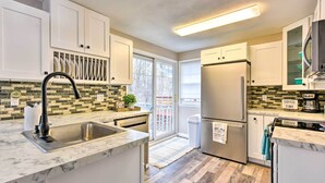 A modern kitchen with white cabinets, a stainless steel refrigerator, and a coffee station. - Walk to Lake Pepin: Charming Retreat w/ Deck (Pepin)