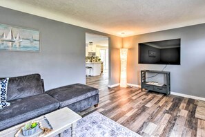 Relax in this stylish living room with a grey sofa, flat-screen TV, and patterned rug.