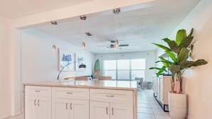 A spacious kitchen with a central island, white cabinetry, pendant lighting, and a ceiling fan. - Walkable Florida Duplex: 2 Blocks to Cocoa Beach! (Cocoa Beach)