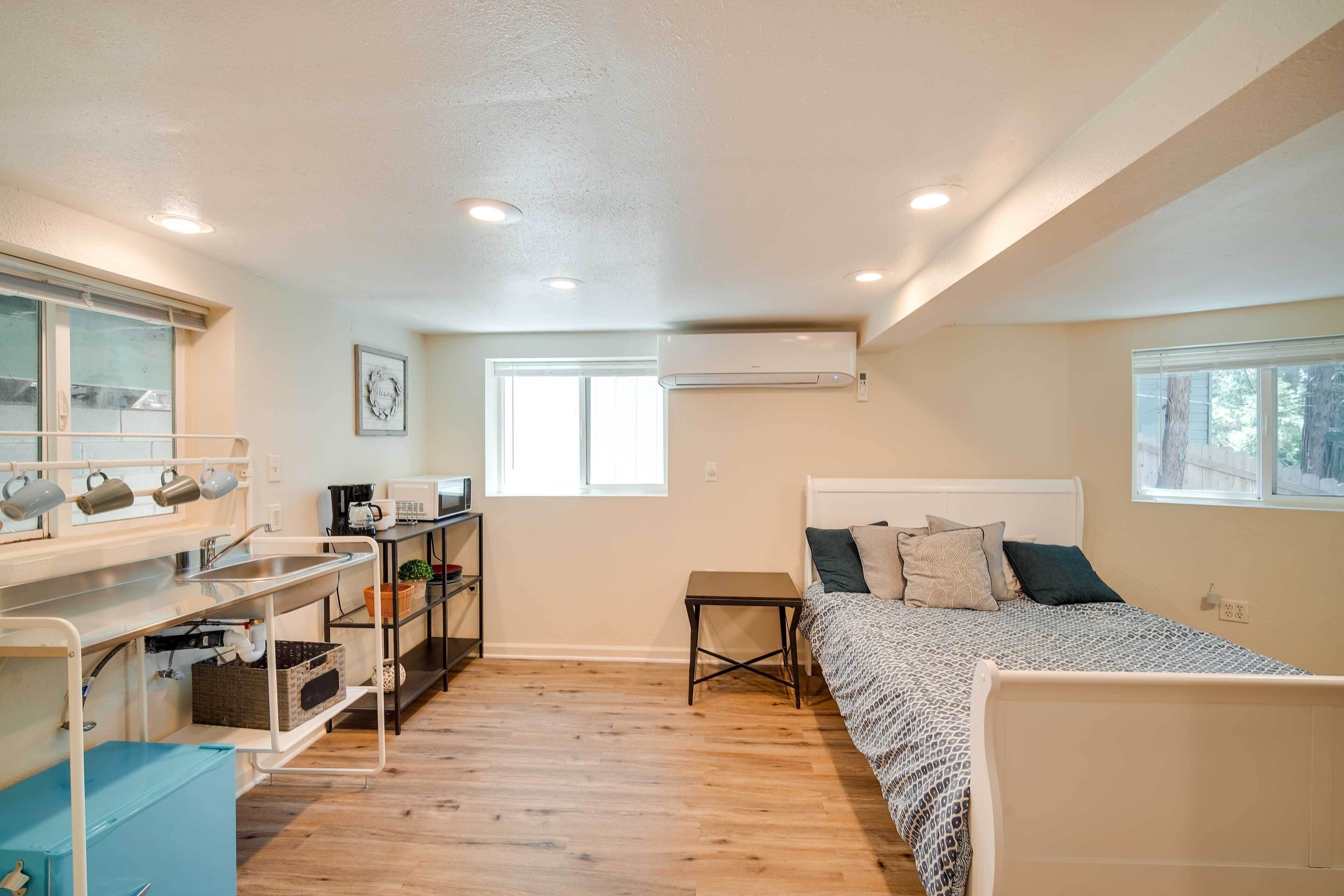 Une chambre à coucher de taille réduite, comprenant un lit, une table de chevet et un petit espace bureau avec un miroir et des étagères.