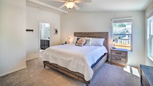 A bedroom with a bed, a nightstand, a dresser, a ceiling fan, and a window.