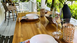 A wooden table set for dining outdoors with white plates, bowls, and glasses. - 🇧🇸 GEAUX FISH Spanish Wells Sea Swings kayak beach snorkel gear! FREE GIFT 🏝️🩵💛🖤🇧🇸 (Spanish Wells)