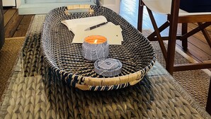 A cozy living room with a wicker coffee table, a flat-screen TV, a bookshelf, and a door leading to a balcony. - 🇧🇸 GEAUX FISH Spanish Wells Sea Swings kayak beach snorkel gear! FREE GIFT 🏝️🩵💛🖤🇧🇸 (Spanish Wells)