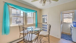 A room with a dining table and chairs, a ceiling fan, and a washing machine. - Boston Area Vacation Rental 3 Mi to Airport! (Revere)
