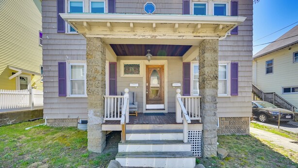 A two-story house with a front porch, stone pillars, and a small front yard. - Boston Area Vacation Rental 3 Mi to Airport! (Revere)
