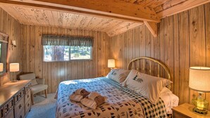 A wooden cabin bedroom with a bed, two bedside lamps, a dresser, and a window with a curtain. - 5 Mi to Heavenly Mountain Resort: All-seasons Gem (South Lake Tahoe)