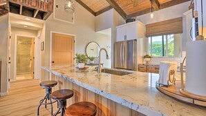 A modern kitchen with a large island, stainless steel appliances, and wooden accents. - Airy Oceanfront Kailua-kona Gem w/ Community Pool (Kailua-Kona)