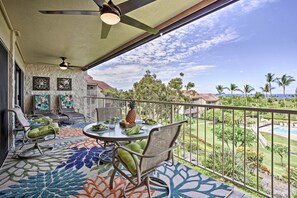 A balcony with a table set for dining, chairs, and a decorative rug. - Ocean-view Lanai! Resort Condo on Kona Coast (Kailua-Kona)