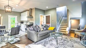 A modern living room with a grey sofa, glass coffee table, and a patterned rug. - Pet-friendly Minneapolis Home ~ 6 Mi to Dtwn! (Minneapolis)