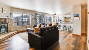 A spacious living area with a fireplace, a black leather sofa, and a kitchen in the background. - 11 Mi to Keystone Resort: Condo in Silverthorne (Silverthorne)