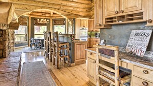 Una cocina rústica con armarios de madera, un banco de piedra y un letrero con texto.