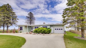 A single-story house with a front driveway, a garage, and a well-maintained lawn. - Waterfront Algoma Vacation Rental on Lake Michigan (Algoma)