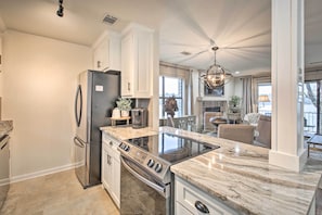 A modern kitchen with a built-in oven, a stainless steel refrigerator, and a marble countertop. - Boat Slip: Lake Hamilton Condo in Hot Springs! (Hot Springs)