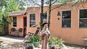 A statue in a garden area with a building in the background. - Charming Casita Studio - Near Santa Fe Plaza! (Santa Fe)