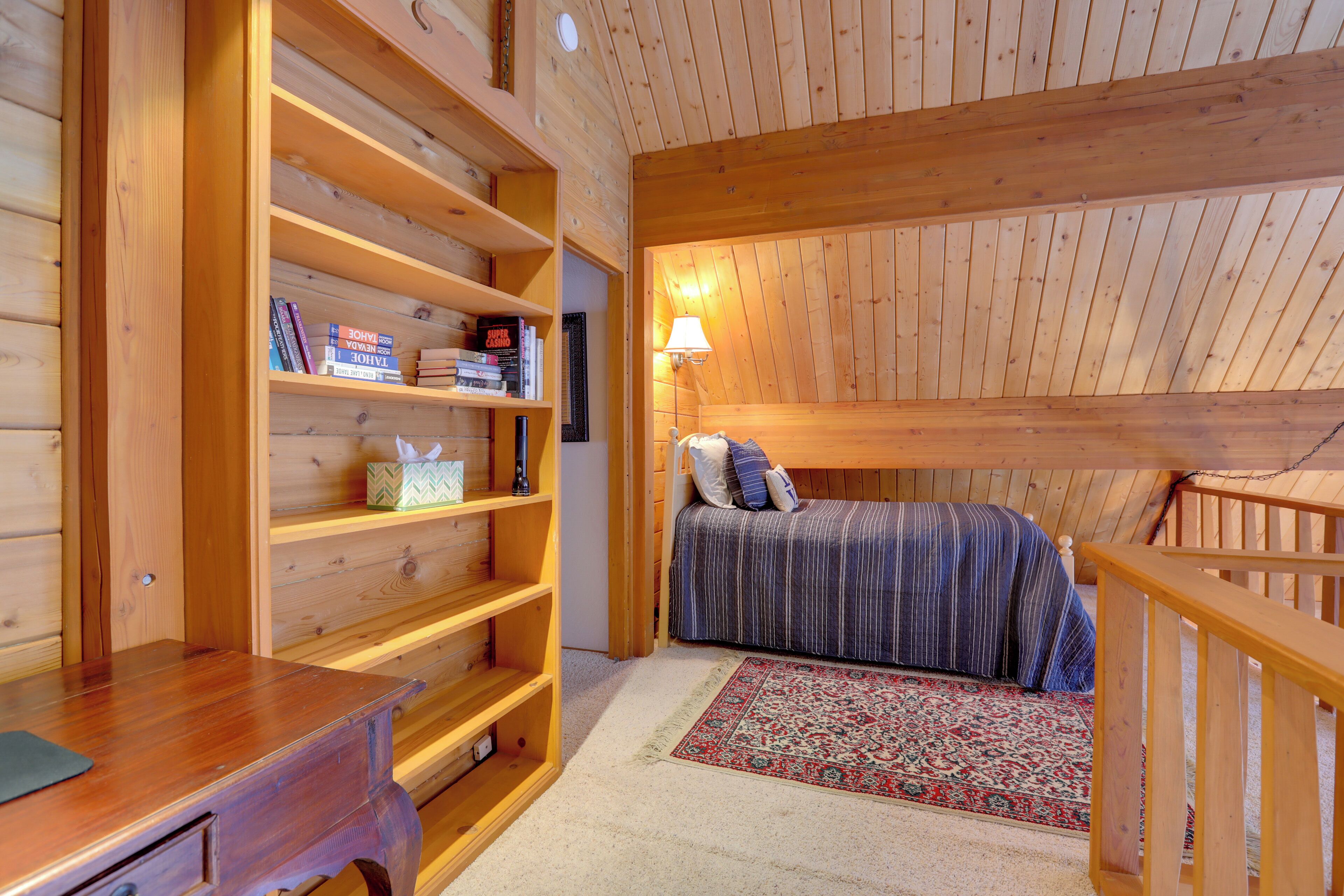 A cozy room with a wooden bed, a bookshelf, and a desk.