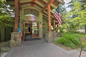 A wooden building entrance with a welcome sign, an American flag, and stone pillars. - 2 Mi to Northstar Resort: Idyllic Cabin w/ Shuttle (Truckee)