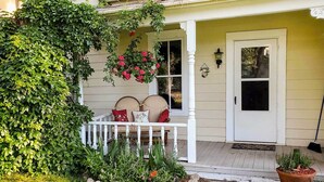 A porch with a white railing, a bench with cushions, and a potted plant. - Charming Buena Vista Creekside Home: Walk to Main! (Buena Vista)
