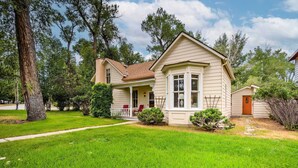 A two-story house with a front porch, a small front yard, and a pathway leading to the entrance. - Charming Buena Vista Creekside Home: Walk to Main! (Buena Vista)