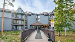 A multi-story building with a wooden deck leading to the entrance. - Silverthorne Condo: New Pool & Hot Tub + Fireplace (Silverthorne)