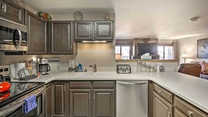 A modern kitchen with stainless steel appliances, a dishwasher, and a large island with a sink. - Silverthorne Condo: New Pool & Hot Tub + Fireplace (Silverthorne)