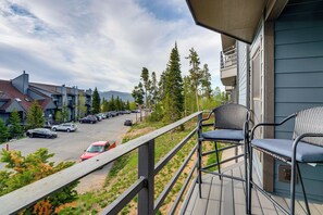 Ein Balkon mit Blick auf einen Parkplatz, Bäume und ein fernes Gebirge.