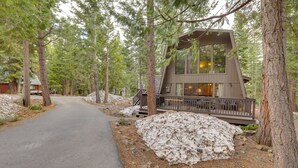 A cabin with a deck, surrounded by trees and a snow-covered ground. - Near Skiing & Hiking: Carnelian Bay Cabin (Carnelian Bay)