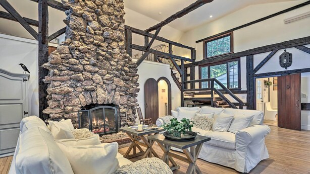 A spacious living room with a stone fireplace, wooden beams, and white furniture. - Historic 1800s Cornwall-on-hudson Cottage! (Cornwall)