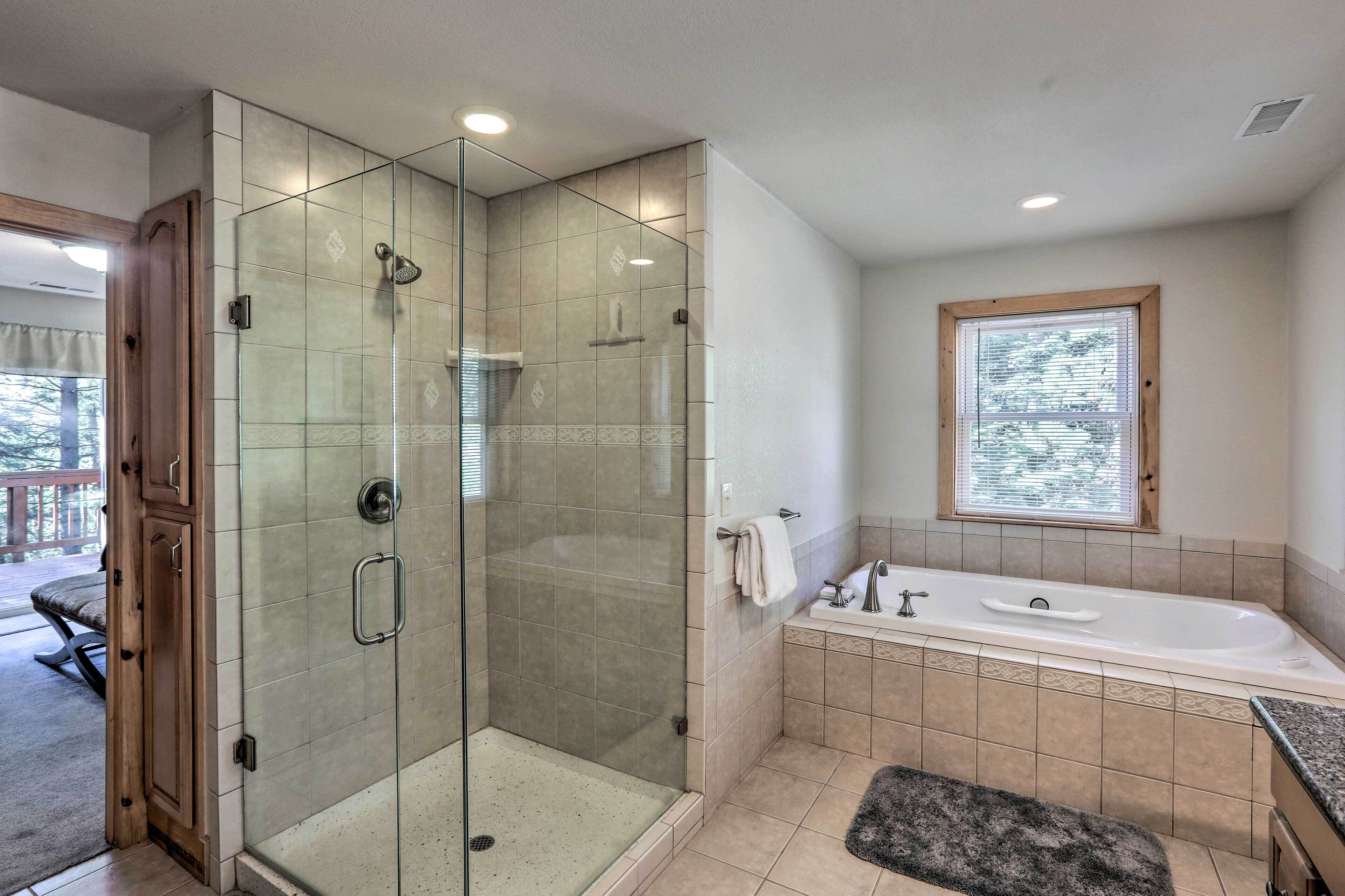 Une salle de bain moderne dotée d’une douche à parois de verre, d’une baignoire sur pieds et d’un meuble-lavabo.