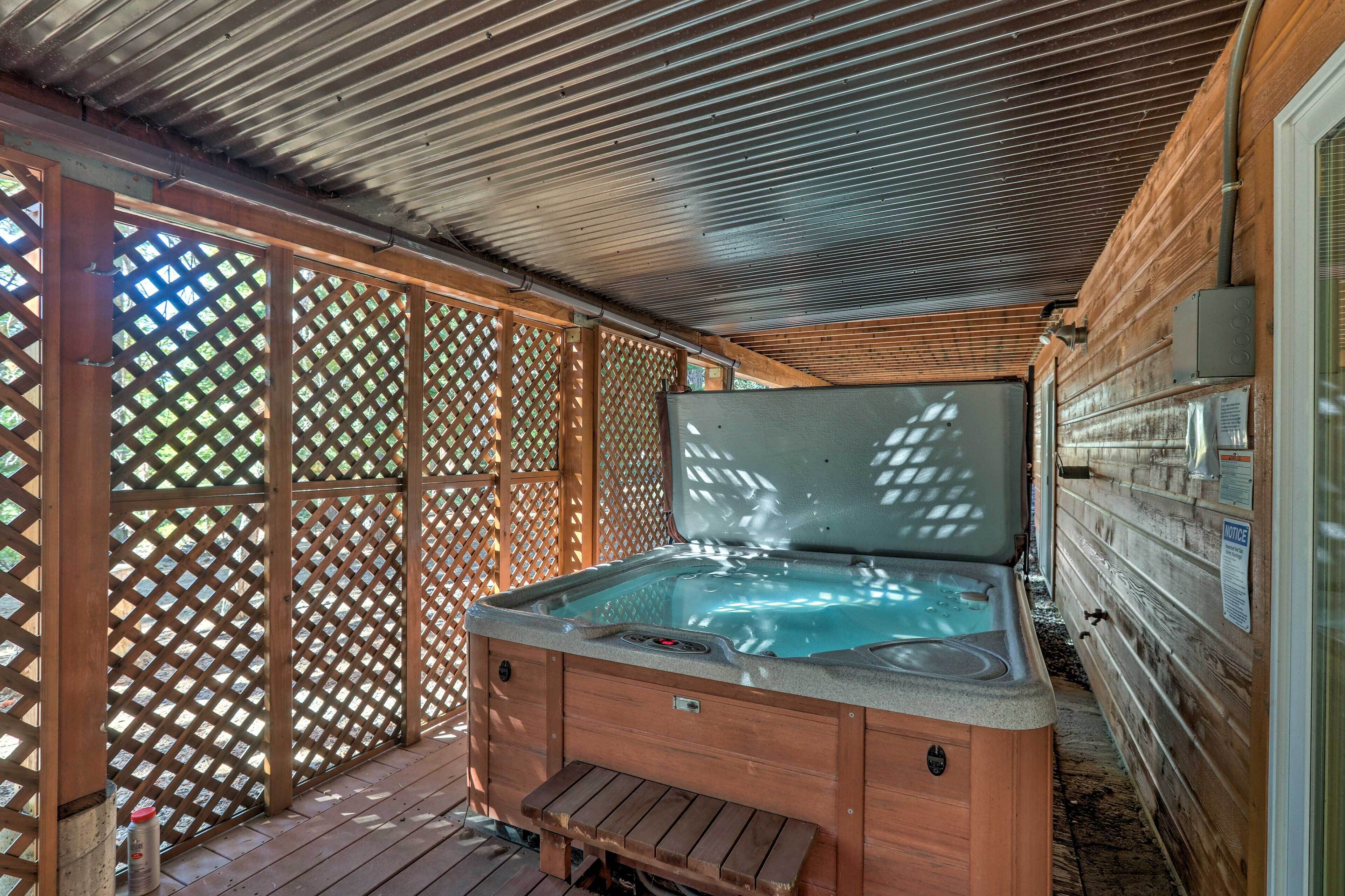 A hot tub in a covered outdoor area with wooden walls and lattice panels.