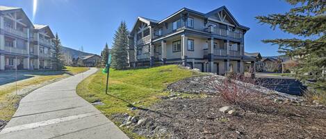 A residential area with multi-story houses, a paved walkway, and a clear sky.