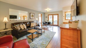 A living room with a sofa, coffee table, and chairs, a dining area with a table and chairs, and a kitchen area with a counter and cabinets. - Mountain-view Retreat - 6 Mi to Ouray Hot Springs! (Ridgway)
