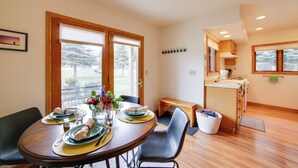 A dining area with a wooden table set for four, a bench, and a view of the outdoors. - Mountain-view Retreat - 6 Mi to Ouray Hot Springs! (Ridgway)