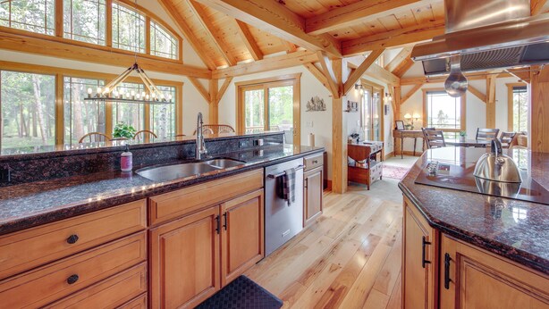 A spacious kitchen with wooden beams, large windows, and a granite countertop. - 7 Mi to Rocky Mtn Nat'l Park: Grand Lake Home! (Grand Lake)