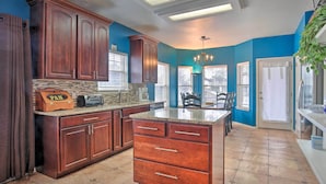 A kitchen with wooden cabinets, a granite countertop, and a built-in island. - San Antonio Home w/ Pool & Hot Tub Near Seaworld! (San Antonio)