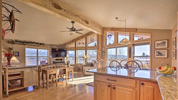 A spacious kitchen with wooden cabinets, a large island, and a dining area with chairs.