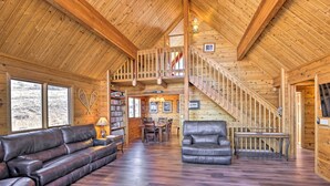 A spacious wooden interior with a high ceiling, a staircase, a leather sofa, a dining area, and a fireplace. - 1 Mi to Granby Ranch: Family-friendly Cabin! (Granby)