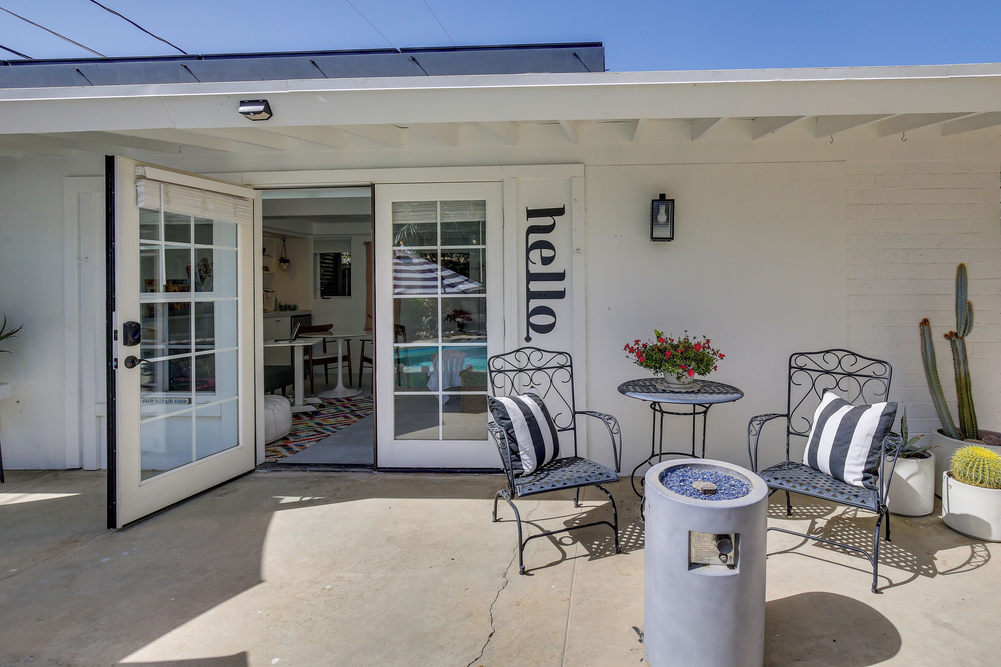 A patio with two metal chairs, a table, and a decorative fire pit.